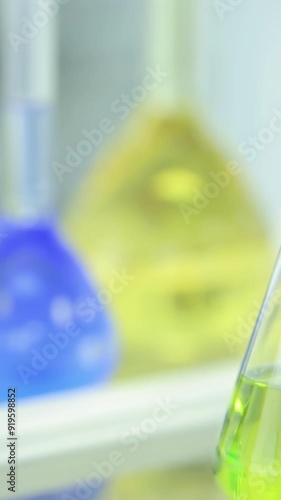 Chemical flasks with green and blue liquid on white background. Test-tubes with colorful chemical reagent. Laboratory glassware. Chemical Laboratory. Selective cocus. Bokeh. scientist and medical photo