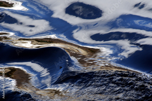 Tableau sur toile Black and blue hued reflections in a small mountain river in Bormio, Valtellina
