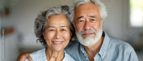  A tight shot of a man and woman grinning at the camera, displaying white beards and graying hair