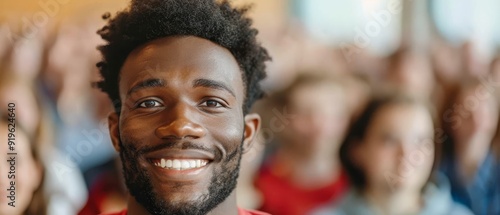  A bearded man stands before a joyful crowd, hands raised in celebration