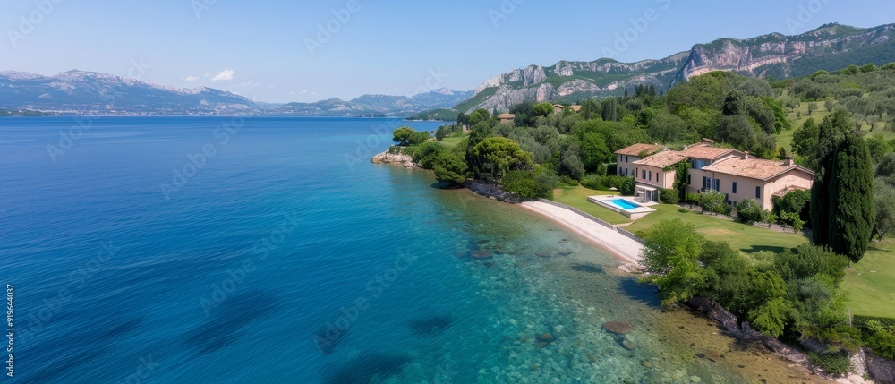 A birds-eye perspective of a lakeside residence featuring a frontal swimming pool and mountainous backdrop A birds-eye perspective of a lakeside residence featuring a frontal swimming pool and mountainous backdrop