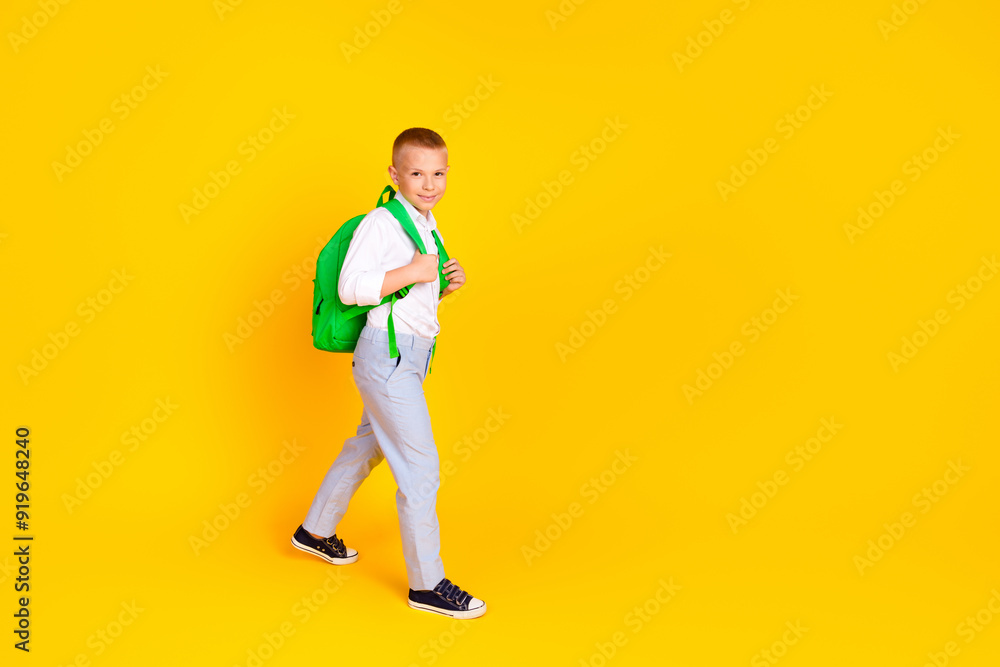 Photo of charming nice boy wear white clothes 1st september empty space isolated on yellow color background Photo of charming nice boy wear white clothes 1st september empty space isolated on yellow color background
