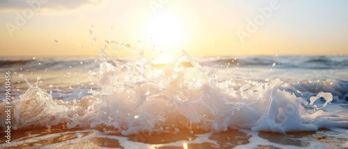  The sun sets over the ocean, painting a splash of water atop foreground rocks