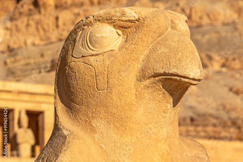 As the symbol of royal power, Horus stands guard at the entrance of Hatshepsut's mortuary temple. The colossal statue of the falcon-headed god is a testament to the queen's divine status.