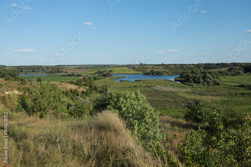 View of hills with a distant pond and fields. Capturing the essence of the Ukrainian rural landscape.