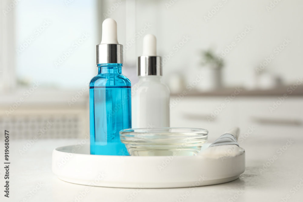 Peeling procedure. Bottles of chemical peel, bowl with liquid and brush on white table indoors Peeling procedure. Bottles of chemical peel, bowl with liquid and brush on white table indoors