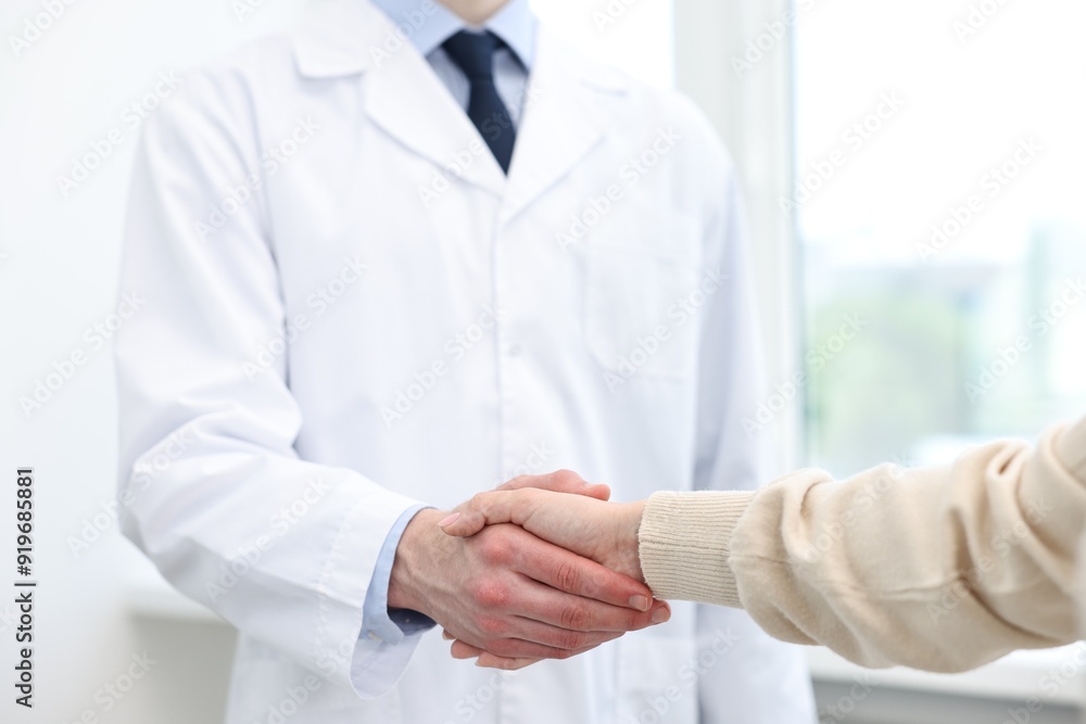Doctor shaking hands with patient in clinic, closeup Doctor shaking hands with patient in clinic, closeup