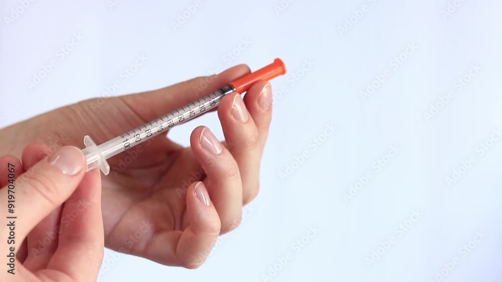 Insulin syringe. A woman's hand holds a syringe on a white background, close-up. Insulin syringe for diabetes. Diabetes treatment. Medicine and health concept Insulin syringe. A woman's hand holds a syringe on a white background, close-up. Insulin syringe for diabetes. Diabetes treatment. Medicine and health concept