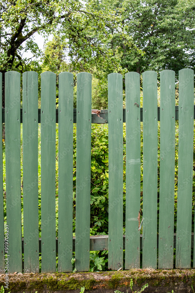 Missing board on green, wooden fence. Abstract concept for damage Missing board on green, wooden fence. Abstract concept for damage