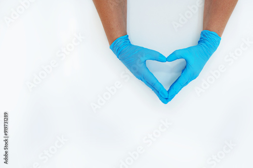 Hands in blue medical gloves folded in the shape of a heart on a white background. photo