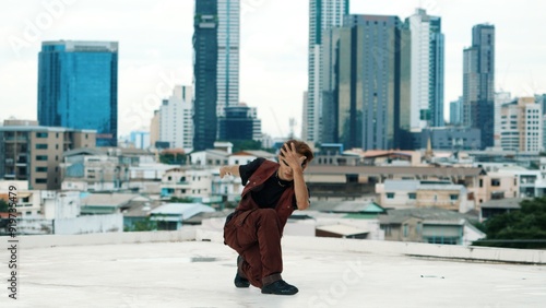 Professional asian break dancer practice B boy dance while multicultural friends at roof top. Young modern dancing group doing hip hop movement. Style,fashion,action. Outdoor sport 2024. Hiphop.