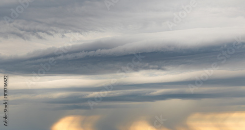 Sky replacement layered blue. gray, white and yellow storm clouds with rain falling