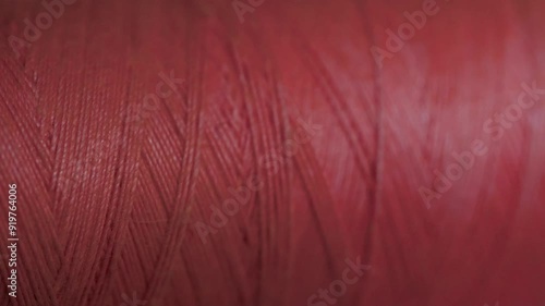 Spool of crimson cotton thread for sewing macro