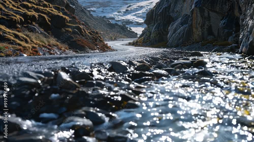 Rocky mountain stream, with clear blue waters reflecting the sunlight amidst snow-covered terrain. Rocky mountain stream, with clear blue waters reflecting the sunlight amidst snow-covered terrain.