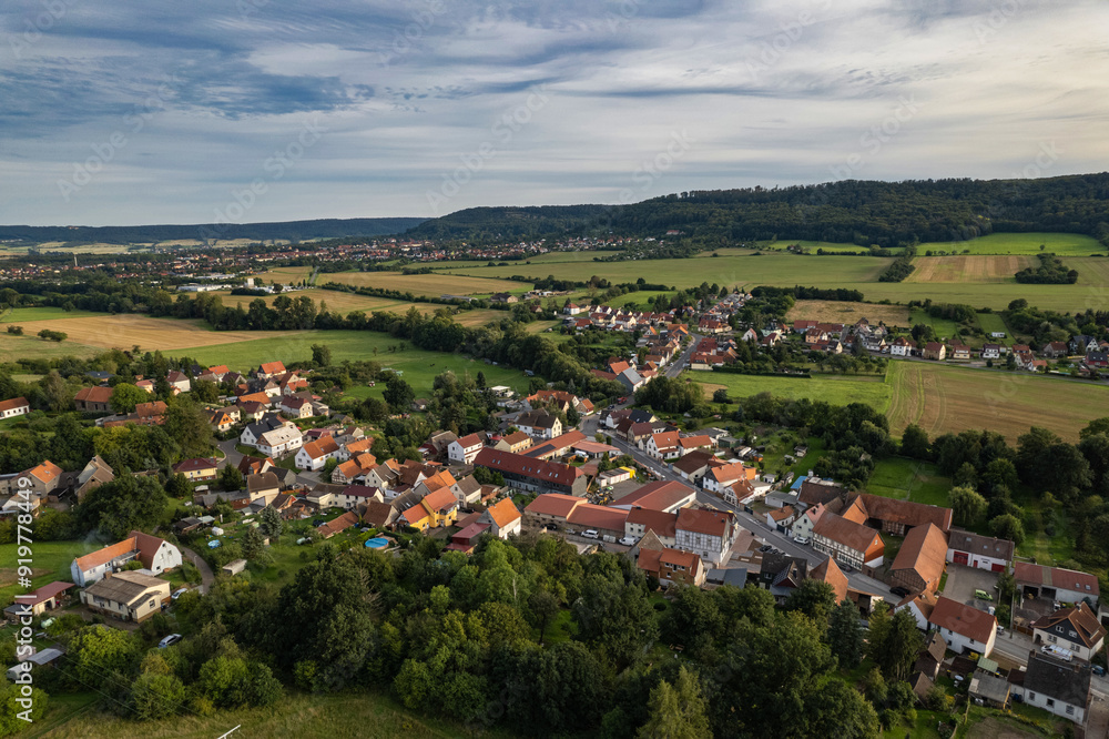 Aer ial view of a German village surrounded by meadows, farmland and forest. Thuringia, Germany.