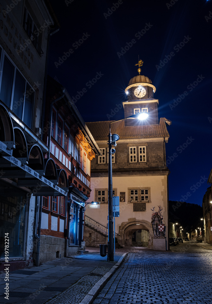 Street alley in the small town of Schwabisch Hall, with houses and buildings with typical German architecture and street lanterns, at night.