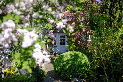 Obraz na płótnie An elegant suburban house surrounded by a lush garden with blooming flowers. Germany. w salonie