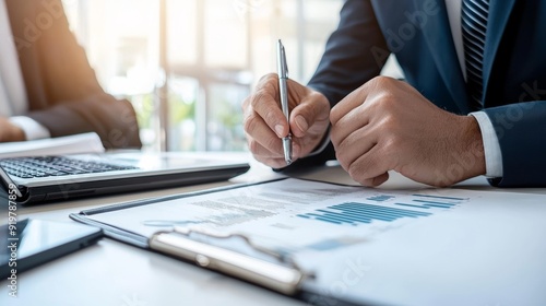 a man in suit writing on piece of paper