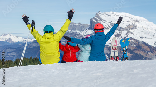 Happy family enjoys scenic mountain ski trip with raised hands photo