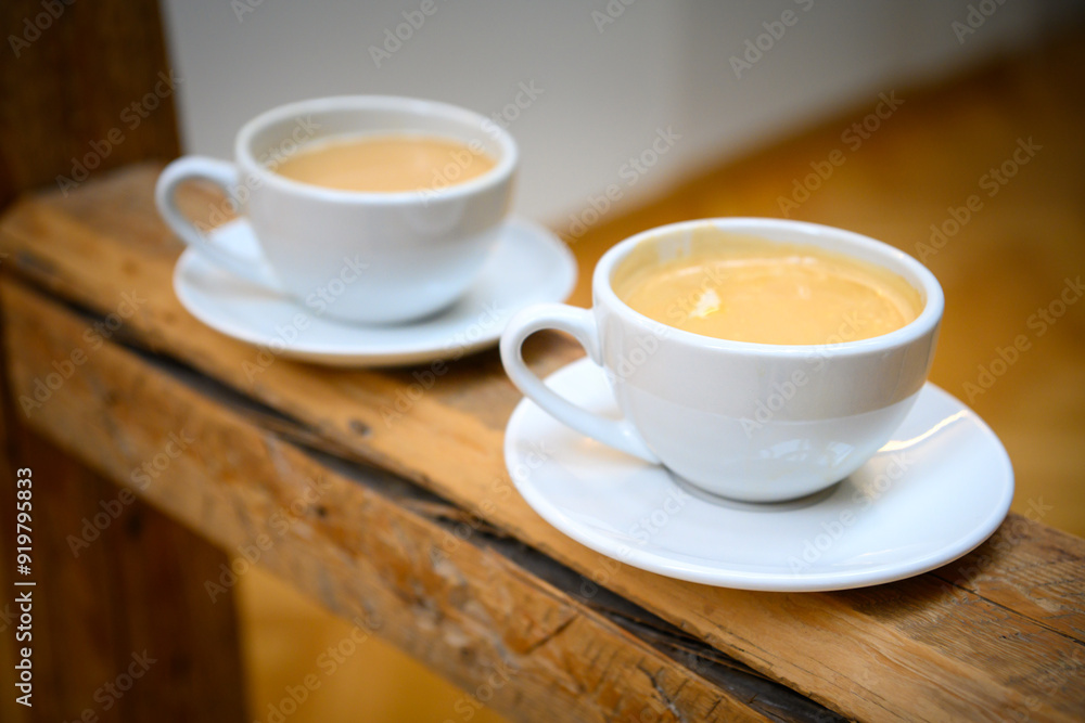 Two cups of hot coffee crema on a rustic bar in an old German café; coffee house with tasting Two cups of hot coffee crema on a rustic bar in an old German café; coffee house with tasting