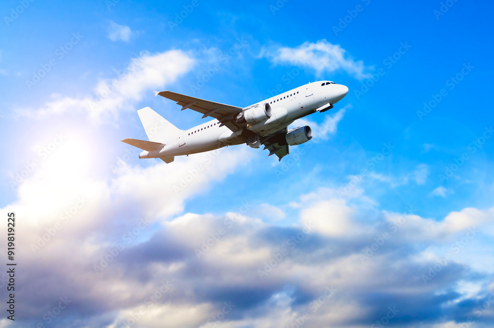 Airplane in the flight, travel background with airplane flying in the blue sky over the clouds. Flying airplane with blank livery Airplane in the flight, travel background with airplane flying in the blue sky over the clouds. Flying airplane with blank livery