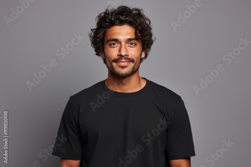 People positive emotions concept. Studio waist up of young happy smiling broadly Hindu man standing in centre isolated on white background wearing black casual t shirt looking straight at camera