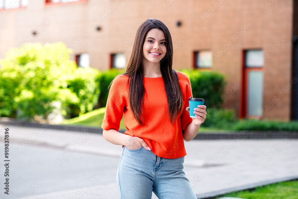 Fototapeta premium Photo of pretty teen good mood girl drinking coffee paper cup wear red clothes walk outside urban city park