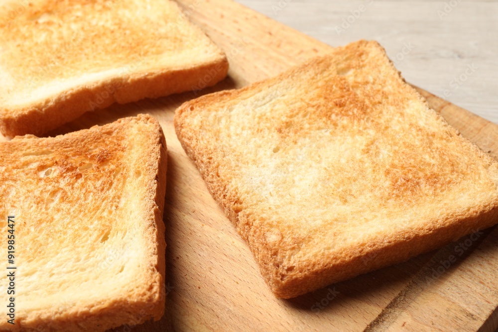 Slices of delicious toasted bread on wooden table, closeup Slices of delicious toasted bread on wooden table, closeup