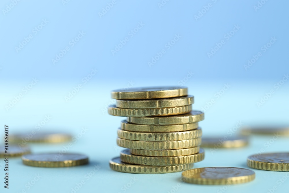 Stack of euro coins on light blue background, closeup Stack of euro coins on light blue background, closeup
