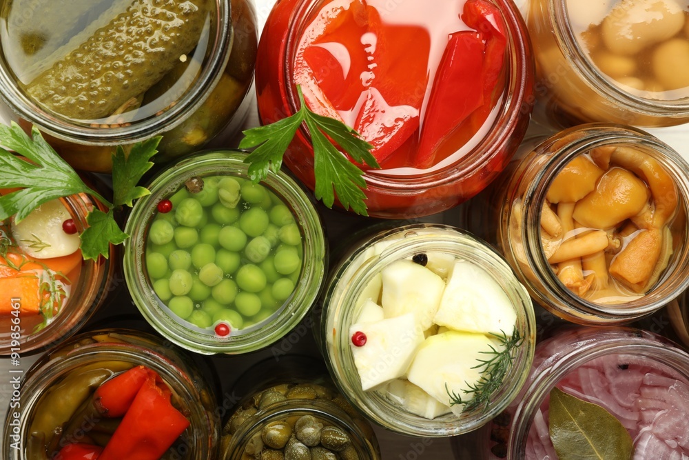 Different pickled products in jars on table, top view Different pickled products in jars on table, top view