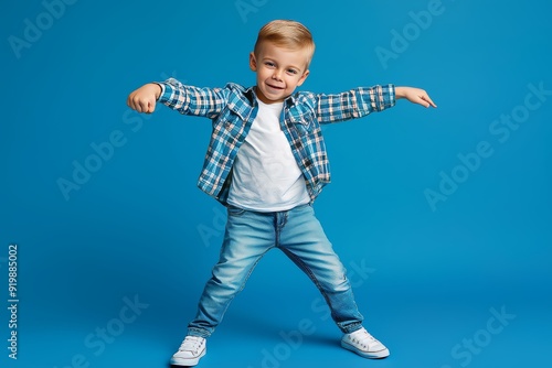 Energetic boy dancing freely in disco style on blue background, expressing weekend positivity