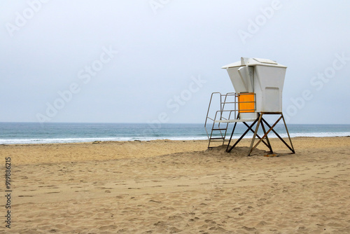 Empty South Mission beach with lonely lifeguard tower in the morning ocean fog, San Diego, California