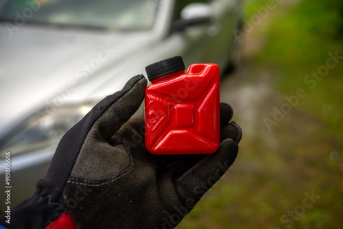 I ran out of gas.The hand holds a fuel canister.Refueling the car. photo