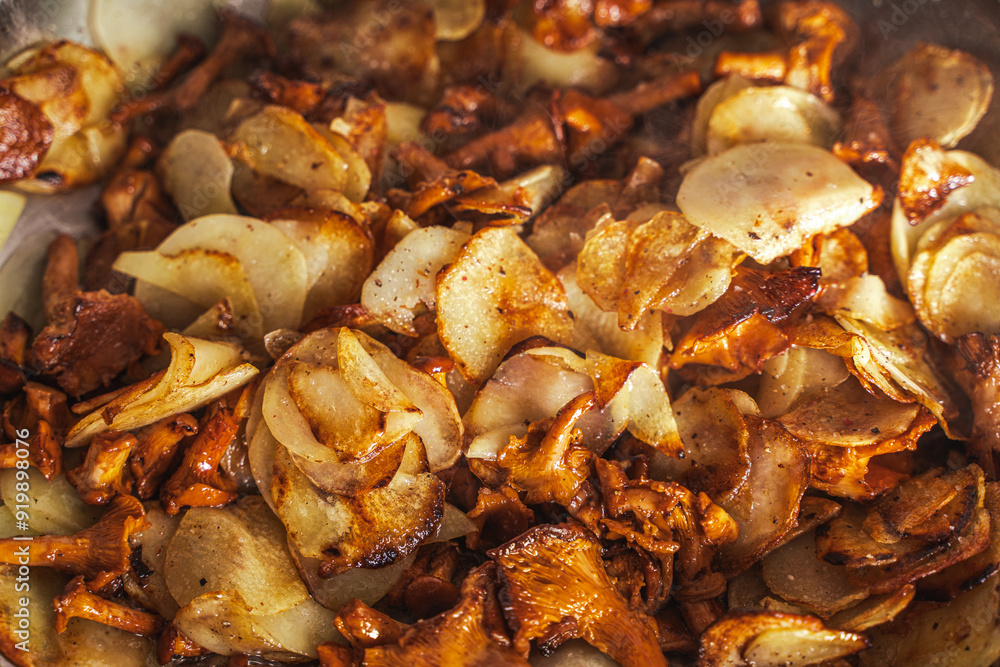 Chanterelle mushrooms with thinly sliced potatoes are fried in a pan. Vegetarian dish. Background. Selected focus. Chanterelle mushrooms with thinly sliced potatoes are fried in a pan. Vegetarian dish. Background. Selected focus.