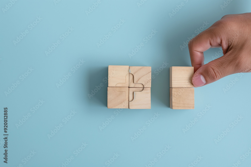 A hand is seen arranging wooden blocks with an engraved plus sign on a pastel blue background, symbolizing growth and positive change A hand is seen arranging wooden blocks with an engraved plus sign on a pastel blue background, symbolizing growth and positive change