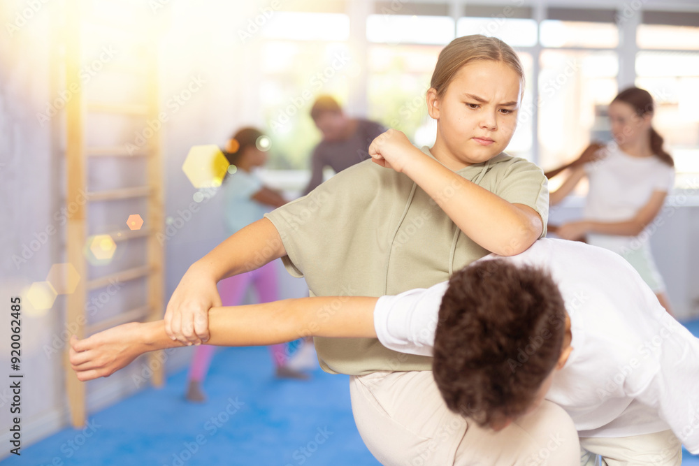 Fototapeta premium Preteen children pairs learning strength self-defense in the gym