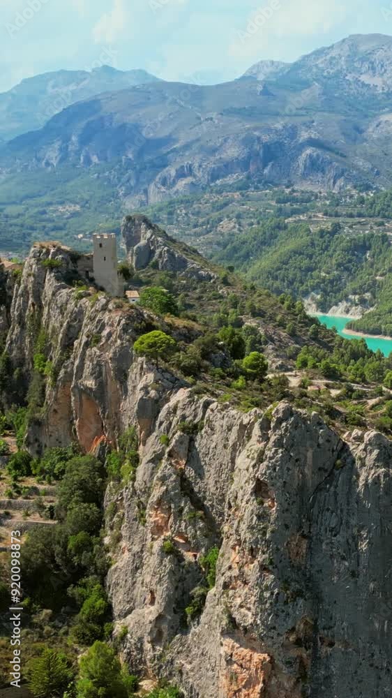 Panoramic view of Guadalest Castle (El Castell de Guadalest) in Alicante. Landmark of Costa Blanca, Spain. Aerial drone nature view with a mountain town on the rock and turquoise reservoir lake. Panoramic view of Guadalest Castle (El Castell de Guadalest) in Alicante. Landmark of Costa Blanca, Spain. Aerial drone nature view with a mountain town on the rock and turquoise reservoir lake.