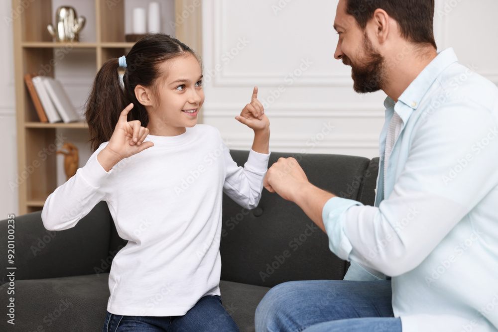 Man and his daughter using sign language for communication at home Man and his daughter using sign language for communication at home