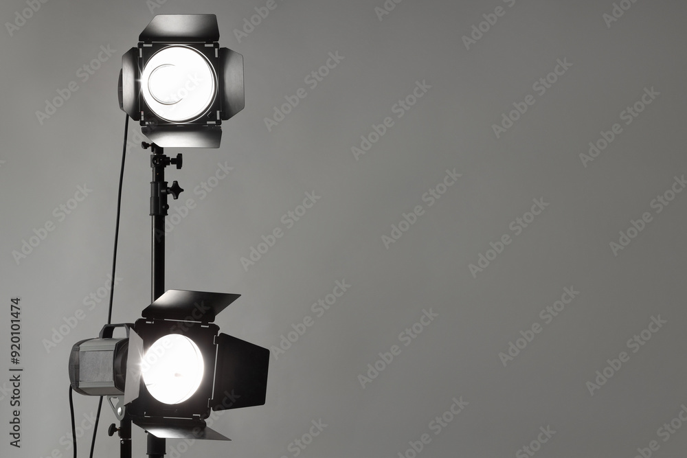 Grey photo background and professional lighting equipment in studio. Space for text Grey photo background and professional lighting equipment in studio. Space for text