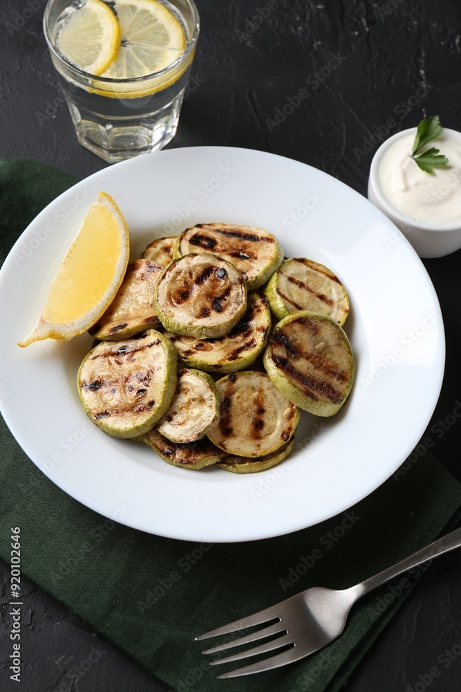 Tasty grilled zucchini slices served on black table, above view Tasty grilled zucchini slices served on black table, above view