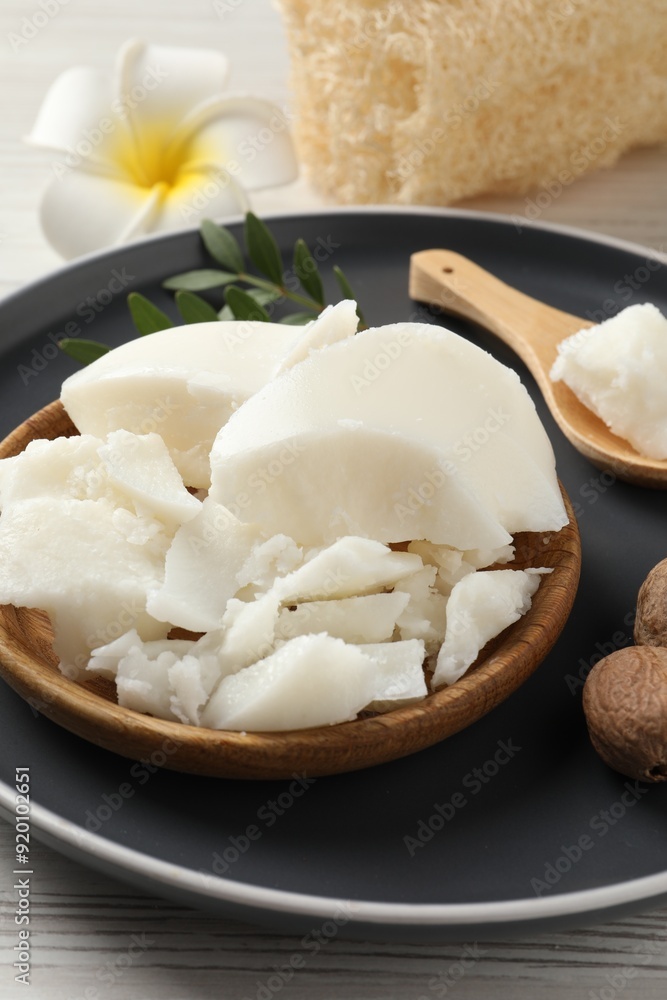 Natural shea butter, nuts, plumeria flower and loofah sponge on wooden table Natural shea butter, nuts, plumeria flower and loofah sponge on wooden table