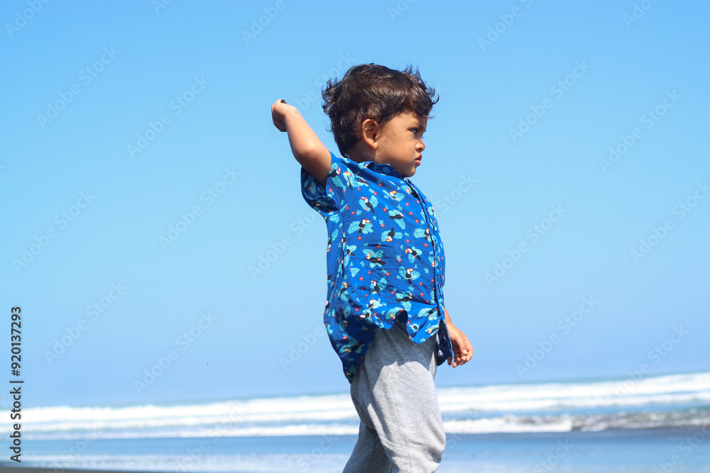 Happy fun Asian child cute little boy playing sand with toy sand tools at a tropical sea beach in holiday summer on sunset time, tourist trip concept Happy fun Asian child cute little boy playing sand with toy sand tools at a tropical sea beach in holiday summer on sunset time, tourist trip concept