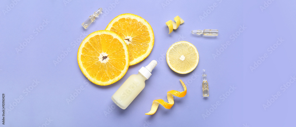 Bottle and ampules of vitamin C with citrus fruit slices on lilac background Bottle and ampules of vitamin C with citrus fruit slices on lilac background