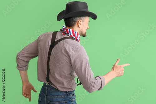 Handsome cowboy on green ba...
