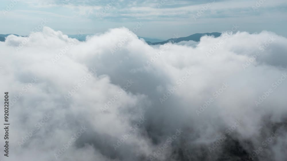 Thick clouds blanket the mountain range creating a mystical and serene aerial view Thick clouds blanket the mountain range creating a mystical and serene aerial view