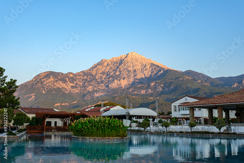 View of Takhtali Mountain reflected in the water of the hotel pool in Turkey, early morning at sunrise photo