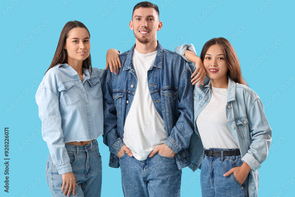 Stylish young people in denim clothes on blue background Stylish young people in denim clothes on blue background