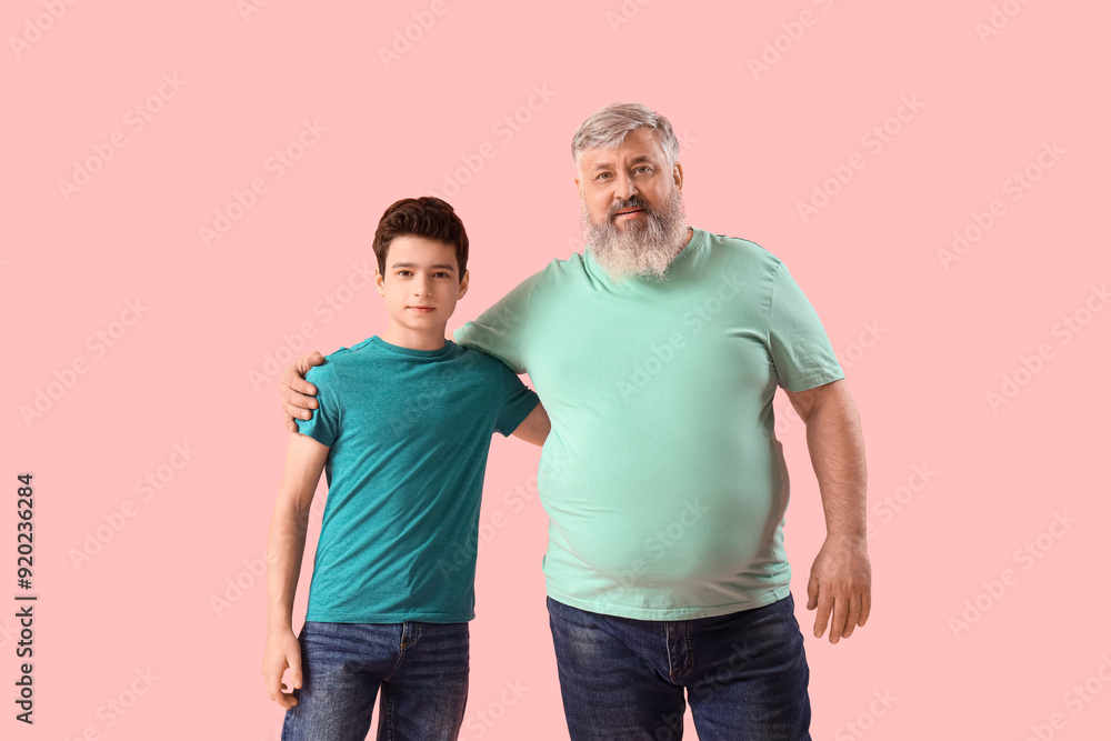 Happy grandfather with his cute grandson on pink background Happy grandfather with his cute grandson on pink background