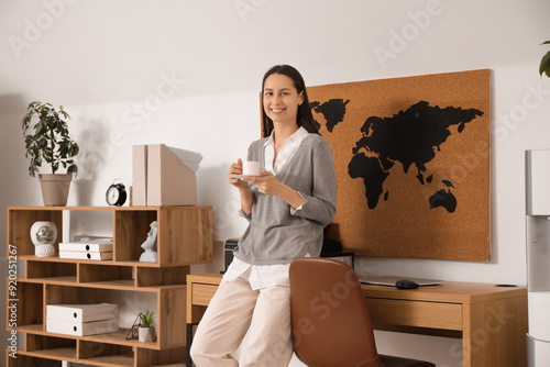 Smiling young woman holding...