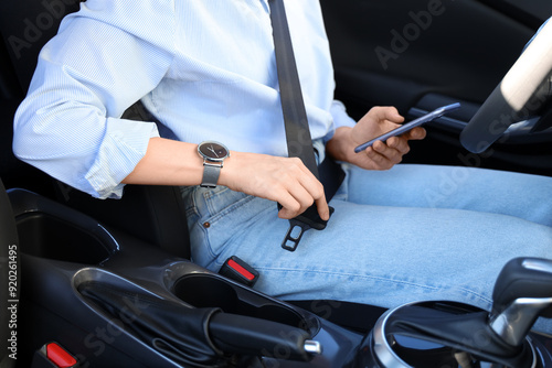 Young woman fastening seat ...